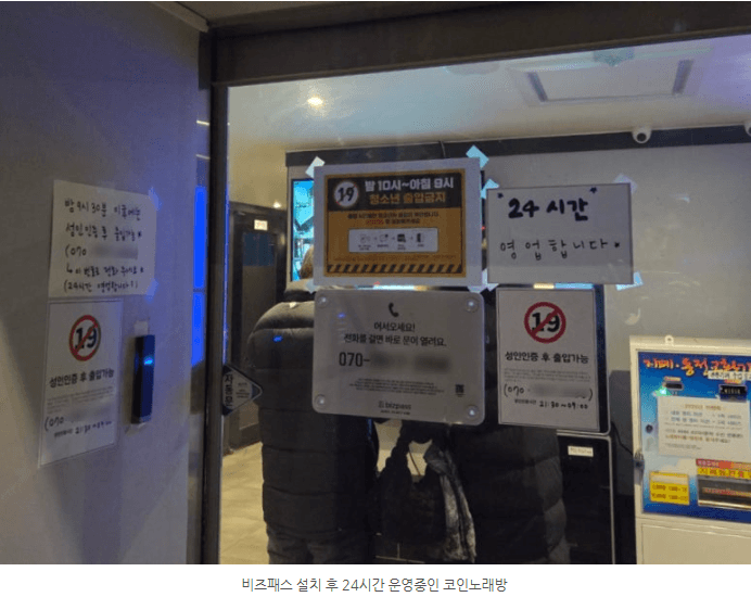 출입문 근처에 붙은 안내판과 24시간 운영 표지