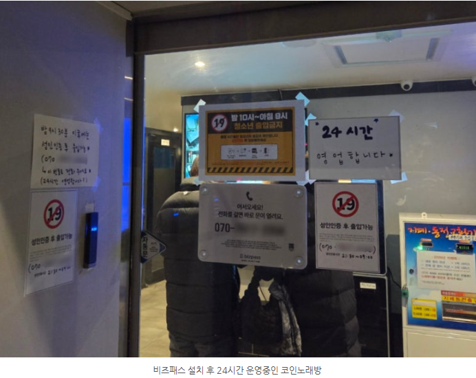 출입문 근처에 붙은 안내판과 24시간 운영 표지